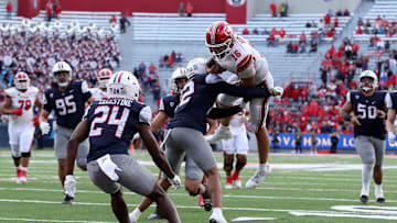 Nov 18, 2023; Tucson, Arizona, USA; Utah Utes quarterback Bryson Barnes (16) is tackled by Arizona Wildcats safety Genesis Smith (12) during the second half at Arizona Stadium. Mandatory Credit: Zachary BonDurant-Imagn Images