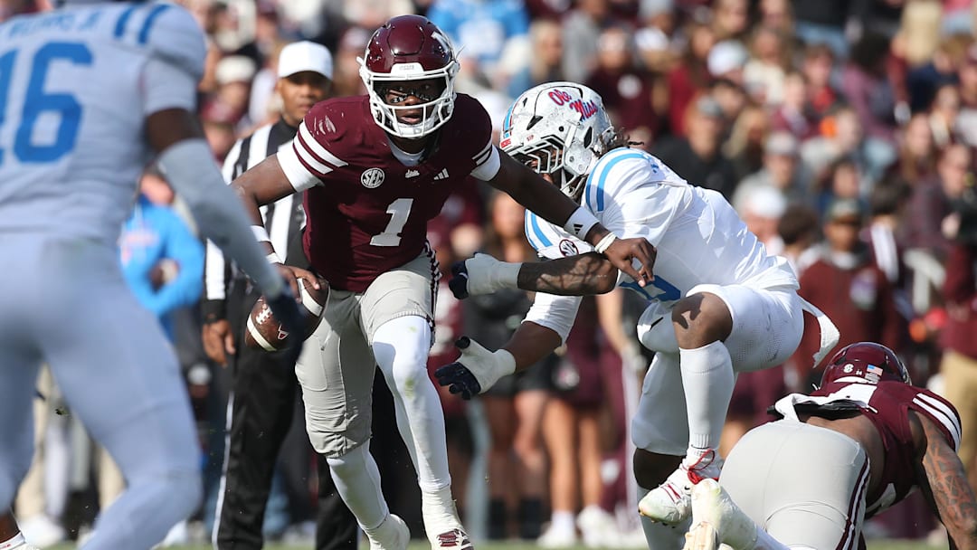 Nov 28, 2025; Starkville, Mississippi, USA; Mississippi State Bulldogs quarterback Kamario Taylor (1) runs against Mississippi Rebels linebacker TJ Dottery (6) in the second half at Davis Wade Stadium at Scott Field. Mandatory Credit: Petre Thomas-Imagn Images