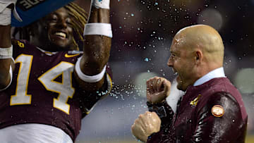 Dec 28, 2021; Phoenix, AZ, USA; Minnesota Golden Gophers head coach P. J. Fleck reacts as he is doused with Powerade by Minnesota Golden Gophers linebacker Braelen Oliver (14) during the second half against the West Virginia Mountaineers at Chase Field. Mandatory Credit: Joe Camporeale-Imagn Images