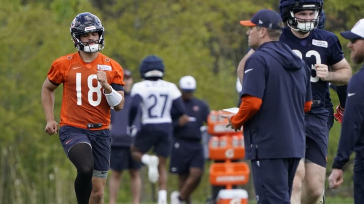 Shane Waldron, right, questions Caleb Williams about a matter during stretching at Bears offseason practice.