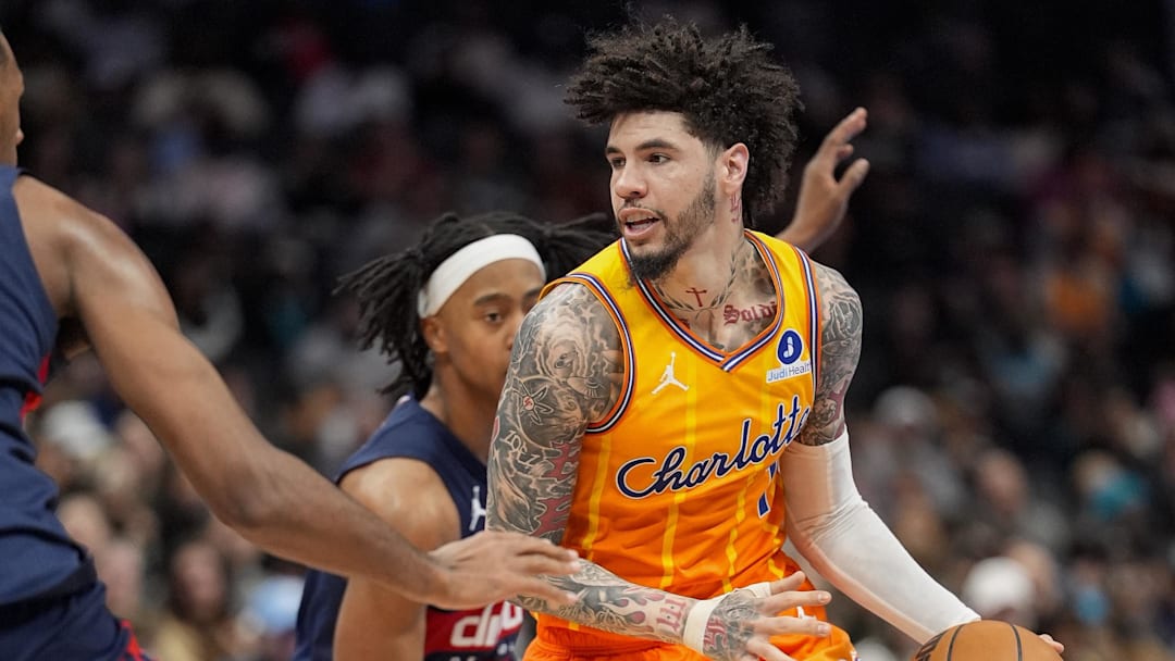 Jan 24, 2026; Charlotte, North Carolina, USA; Charlotte Hornets guard LaMelo Ball (1) handles the ball against Washington Wizards center Alex Sarr (20) and guard Tre Johnson (12) during the second half at the Spectrum Center. Mandatory Credit: Jim Dedmon-Imagn Images