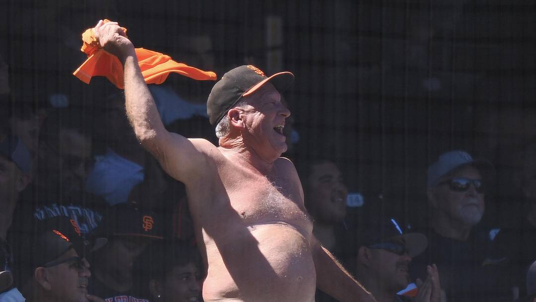 San Francisco, California, USA; A San Francisco Giants fan waves his shirt during the eighth inning against the Washington Nationals at Oracle Park. Mandatory Credit: Kelley L Cox-Imagn Images