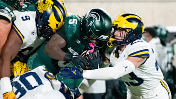 Oct 25, 2025; East Lansing, Michigan, USA; Michigan State Spartans running back Makhi Frazier (5) is tackled by Michigan Wolverines linebacker Cole Sullivan (23) during the first half at Spartan Stadium. Mandatory Credit: Brendan Mullin-Imagn Images