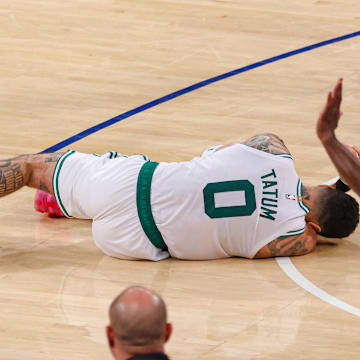 Boston Celtics forward Jayson Tatum lays on the court after suffering an injury.