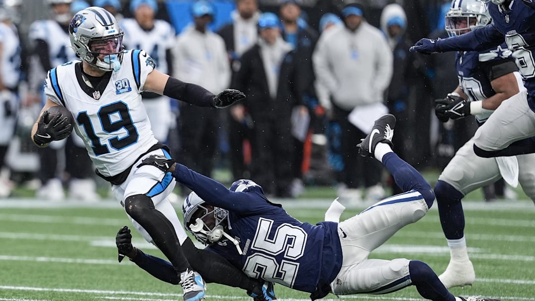 Dec 15, 2024; Charlotte, North Carolina, USA;  Carolina Panthers wide receiver Adam Thielen (19) is tackled by  Dallas Cowboys cornerback Andrew Booth Jr. (25) during the second half at Bank of America Stadium.