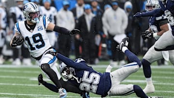 Dec 15, 2024; Charlotte, North Carolina, USA;  Carolina Panthers wide receiver Adam Thielen (19) is tackled by  Dallas Cowboys cornerback Andrew Booth Jr. (25) during the second half at Bank of America Stadium.