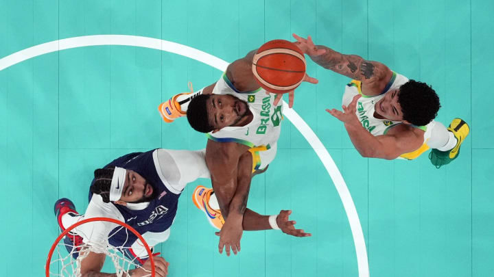 Aug 6, 2024; Paris, France; Brazil shooting guard Gui Santos (11) and power forward Bruno Caboclo (51) reach for the rebound against United States centre Anthony Davis (14) in the second half in a men’s basketball quarterfinal game during the Paris 2024 Olympic Summer Games at Accor Arena. Mandatory Credit: Kyle Terada-USA TODAY Sports