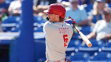 Feb 26, 2025; Dunedin, Florida, USA; Philadelphia Phillies second base Bryson Stott (5) hits an rbi single against the Toronto Blue Jays in the sixth inning during spring training at TD Ballpark.
