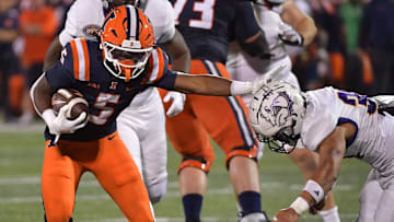 Aug 29, 2025; Champaign, Illinois, USA;  Illinois Fighting Illini running back Ca'Lil Valentine (5) stiff arms Western Illinois Leathernecks defensive back Christian Pierce (3) during the second half at Memorial Stadium. Mandatory Credit: Ron Johnson-Imagn Images