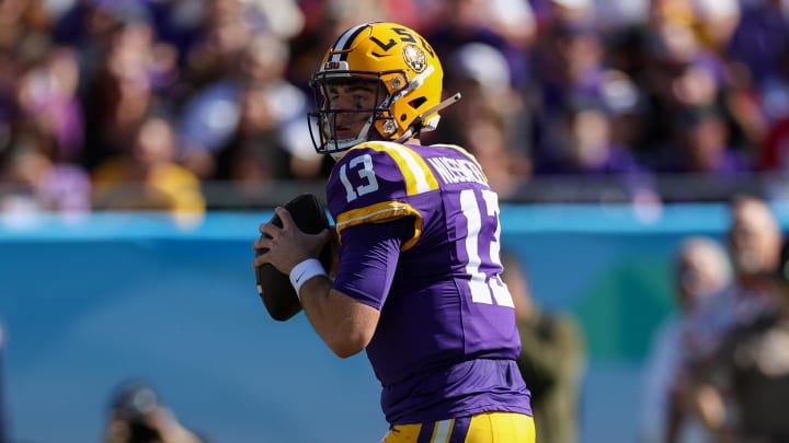 Jan 1, 2024; Tampa, FL, USA;  LSU Tigers quarterback Garrett Nussmeier (13) drops back to pass against the Wisconsin Badgers in the first quarter during the ReliaQuest Bowl at Raymond James Stadium. Mandatory Credit: Nathan Ray Seebeck-USA TODAY Sports