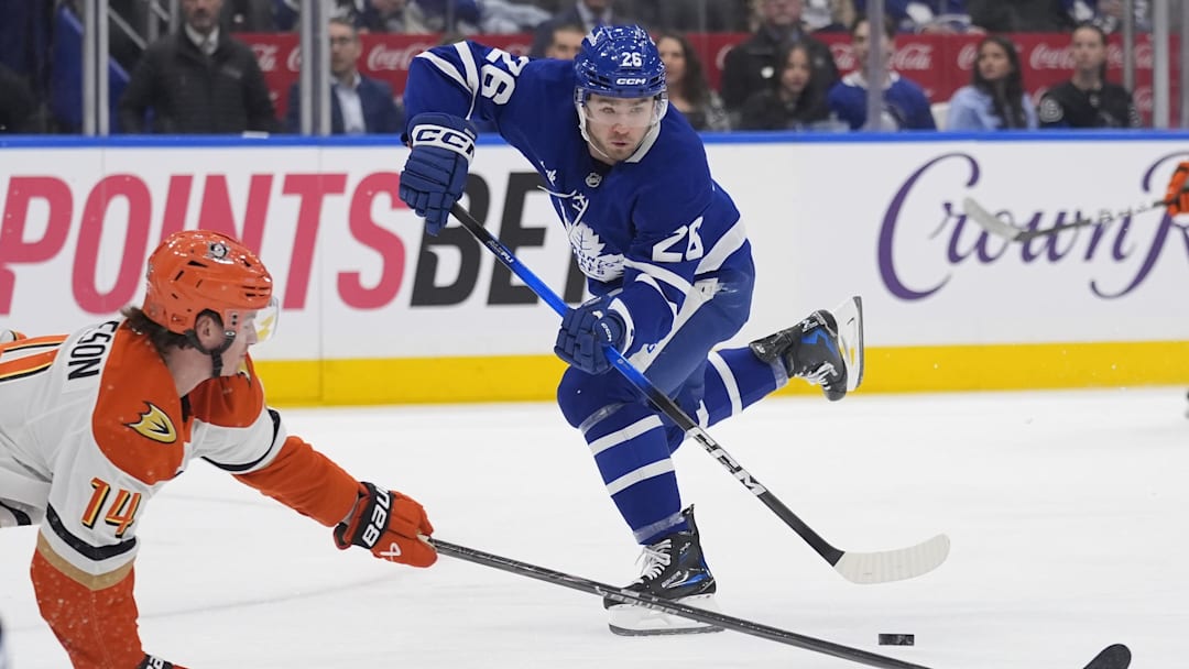 Mar 12, 2026; Toronto, Ontario, CAN; Toronto Maple Leafs forward Jacob Quillan (26) passes the puck as Anaheim Ducks defenseman Drew Helleson (14) defends during the third period at Scotiabank Arena. Mandatory Credit: John E. Sokolowski-Imagn Images
