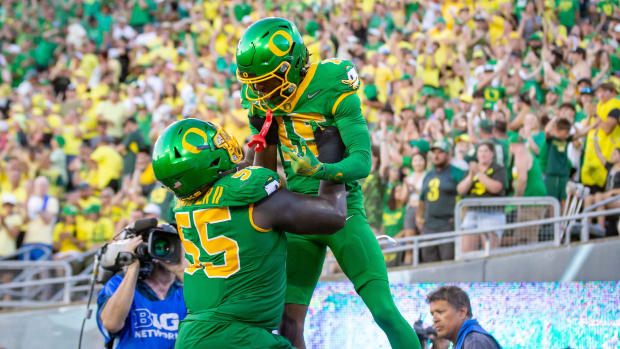 Oregon Ducks offensive lineman Marcus Harper II lifts Oregon Ducks wide receiver Tez Johnson into the air after a touchdown