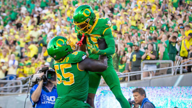 Oregon Ducks offensive lineman Marcus Harper II lifts Oregon Ducks wide receiver Tez Johnson into the air after a touchdown