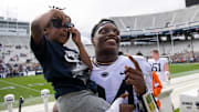 Penn State freshman Ta'Mere Robinson poses for a photo with a young fan following the Blue-White game at Beaver Stadium on Saturday, April 15, 2023, in State College.