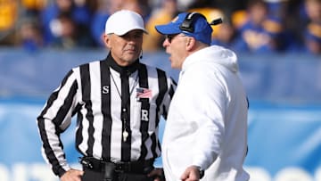 Nov 29, 2025; Pittsburgh, Pennsylvania, USA;  Pittsburgh Panthers head coach Pat Narduzzi (right) talks with referee Riley Johnson (left) during the first quarter against the Miami Hurricanes at Acrisure Stadium. Mandatory Credit: Charles LeClaire-Imagn Images