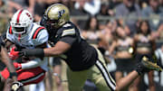 Ball State Cardinals running back Qua Ashley (9) is tackled by Purdue Boilermakers defensive lineman TJ Lindsey (13) 