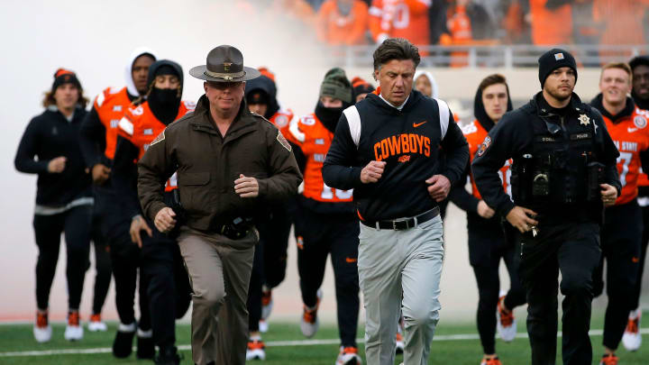 Oklahoma State head coach Mike Gundy runs on to the field before the college football game between the Oklahoma State University Cowboys and the Brigham Young Cougars at Boone Pickens Stadium in Stillwater, Okla., Saturday, Nov., 25, 2023.