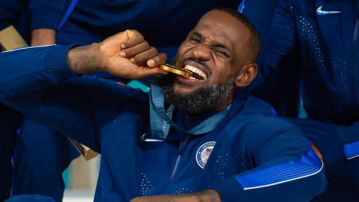 LeBron James haciendo la clásica mordida de su medalla de oro en los Juegos Olímpicos de París 2024 