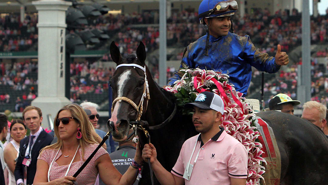 Jockey Luis Saez gives a thumbs up to the crowd in the Winners Circle, after winning the 151st Kentucky Oaks aboard Good Cheer.