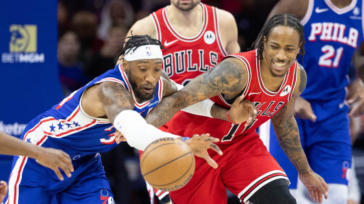 Dec 18, 2023; Philadelphia, Pennsylvania, USA; Philadelphia 76ers forward Robert Covington (33) and Chicago Bulls forward DeMar DeRozan (11) compete for a loose ball during the fourth quarter at Wells Fargo Center. Mandatory Credit: Bill Streicher-USA TODAY Sports