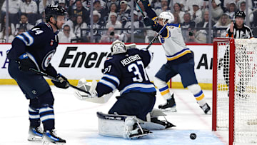 Apr 21, 2025; Winnipeg, Manitoba, CAN;St. Louis Blues right wing Jimmy Snuggerud (21) (not shown) score on Winnipeg Jets goaltender Connor Hellebuyck (37) as teammate St. Louis Blues center Robert Thomas (18) celebrates in the first period in game two of the first round of the 2025 Stanley Cup Playoffs at Canada Life Centre. Mandatory Credit: James Carey Lauder-Imagn Images