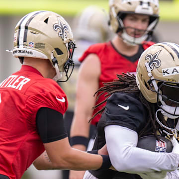 Jun 10, 2025; New Orleans, LA, USA;  New Orleans Saints quarterback Spencer Rattler (2) hands the ball off to running back Alvin Kamara (41) during minicamp at Ochsner Sports Performance Center. Mandatory Credit: Stephen Lew-Imagn Images
