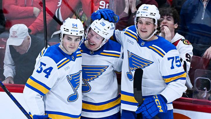 Jan 7, 2026; Chicago, Illinois, USA; St. Louis Blues center Otto Stenberg (28) celebrates with right wing Dalibor Dvorsky (54) and  defenseman Tyler Tucker (75) after scoring against the Chicago Blackhawks during the second period at the United Center. Mandatory Credit: Matt Marton-Imagn Images