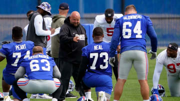 New York Giants head coach Brian Daboll greets offensive tackle Evan Neal (73) on day two of