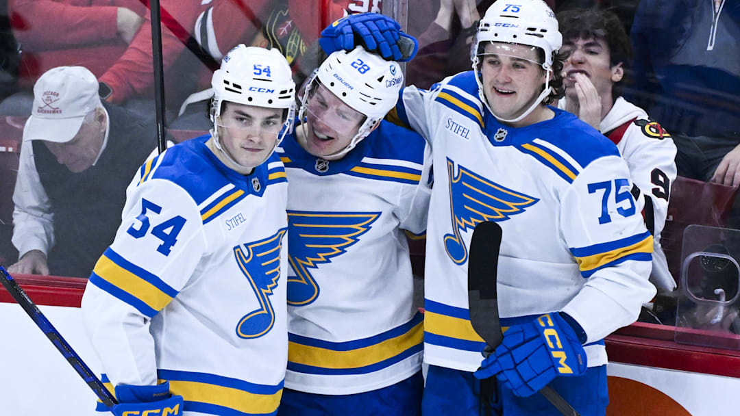 Jan 7, 2026; Chicago, Illinois, USA; St. Louis Blues center Otto Stenberg (28) celebrates with right wing Dalibor Dvorsky (54) and  defenseman Tyler Tucker (75) after scoring against the Chicago Blackhawks during the second period at the United Center. Mandatory Credit: Matt Marton-Imagn Images