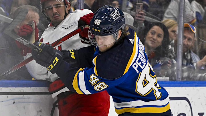 Apr 12, 2024; St. Louis, Missouri, USA;  St. Louis Blues defenseman Scott Perunovich (48) checks Carolina Hurricanes center Seth Jarvis (24) during the third period at Enterprise Center. Mandatory Credit: Jeff Curry-Imagn Images