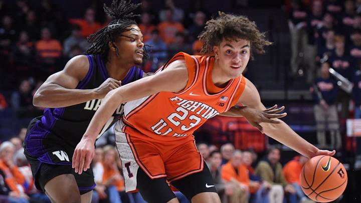 Jan 29, 2026; Champaign, Illinois, USA;  Illinois Fighting Illini guard Keaton Wagler (23) drives the ball past Washington Huskies guard Wesley Yates III (9) during the first half at State Farm Center. Mandatory Credit: Ron Johnson-Imagn Images