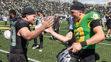 Combat Duck Jack Ressler, left, greets Fighting Duck quarterback Luke Moga after the Oregon Spring Game at Autzen Stadium.
