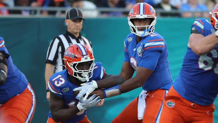 Dec 20, 2024; Tampa, FL, USA; Florida Gators quarterback DJ Lagway (2) hands the ball to Florida Gators running back Jadan Baugh (13) during the second quarter at Raymond James Stadium. Mandatory Credit: Kim Klement Neitzel-Imagn Images