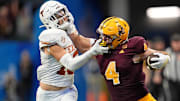 Arizona State Sun Devils running back Cam Skattebo (4) stiff arms Texas Longhorns defensive back Michael Taaffe (16) during the second half of the Peach Bowl at Mercedes-Benz Stadium.