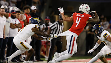 Sep 7, 2024; Tucson, Arizona, USA; Northern Arizona Lumberjacks center back DJ Vanhook (4) attempts to tackle Arizona Wildcats wide receiver Tetairoa McMillan (4) during the third quarter at Arizona Stadium.