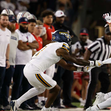 Sep 7, 2024; Tucson, Arizona, USA; Northern Arizona Lumberjacks center back DJ Vanhook (4) attempts to tackle Arizona Wildcats wide receiver Tetairoa McMillan (4) during the third quarter at Arizona Stadium.