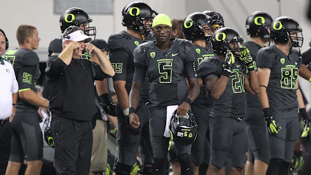 Oregon Ducks quarterback Darron Thomas (5) running back LaMichael James (21) and head coach Chip Kelly (left)