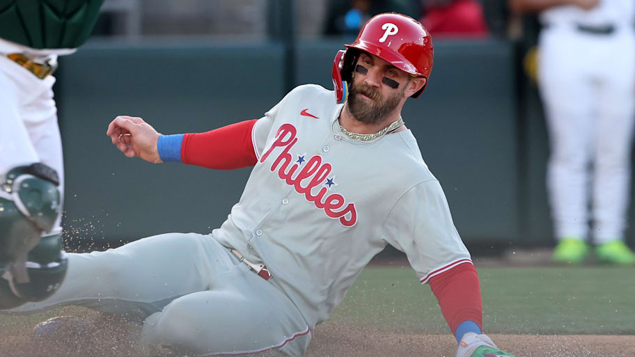 Philadelphia Phillies star Bryce Harper slides into home plate to score a run. | Dennis Lee-Imagn Images