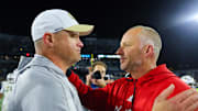 Nov 21, 2024; Atlanta, Georgia, USA; Georgia Tech Yellow Jackets head coach Brent Key talks to North Carolina State Wolfpack head coach Dave Doeren after a game at Bobby Dodd Stadium at Hyundai Field. Mandatory Credit: Brett Davis-Imagn Images
