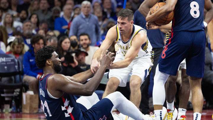 Nov 14, 2023; Philadelphia, Pennsylvania, USA; Indiana Pacers guard T.J. McConnell (9) helps Philadelphia 76ers center Joel Embiid (21) off the floor after fouling him during the third quarter at Wells Fargo Center. Mandatory Credit: Bill Streicher-USA TODAY Sports