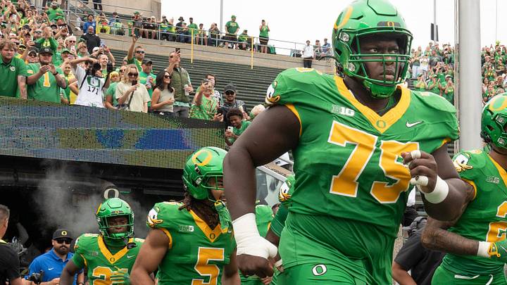 Oregon’s Emmanuel Pregnon, center, takes the field before the game against Oklahoma State at Autzen.