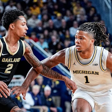 Michigan guard Trey McKenney (1) dribbles against Oakland guard Ziare Wells (2) during the first half at Crisler Center in Ann Arbor on Monday, November 3, 2025.