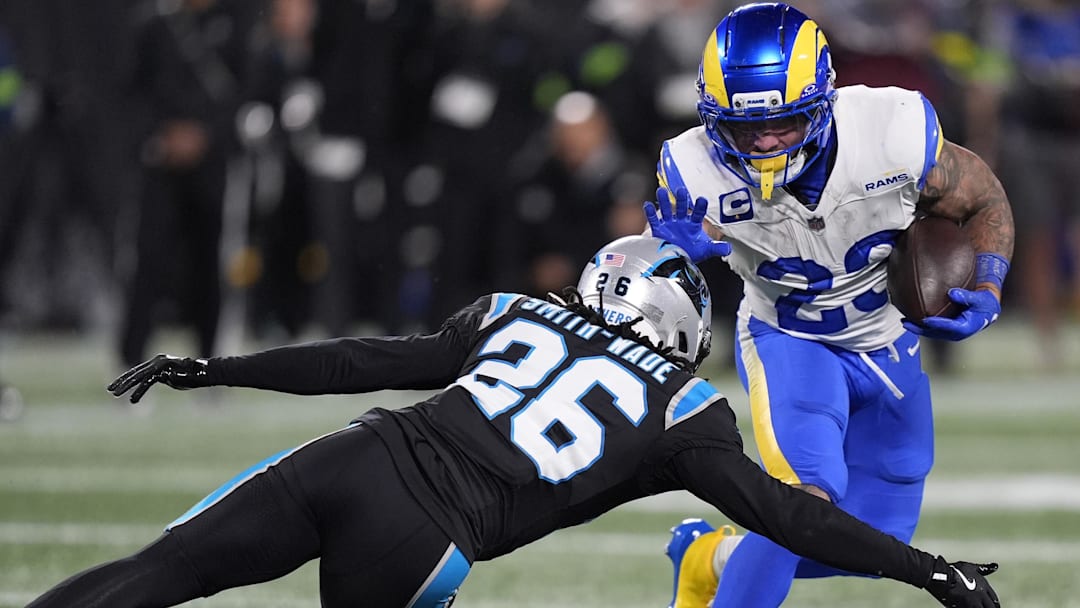 Jan 10, 2026; Charlotte, NC, USA; Los Angeles Rams running back Kyren Williams (23) rushes the ball against Carolina Panthers cornerback Chau Smith-Wade (26)  in the second half during the NFC Wild Card Round game at Bank of America Stadium. Mandatory Credit: Jim Dedmon-Imagn Images