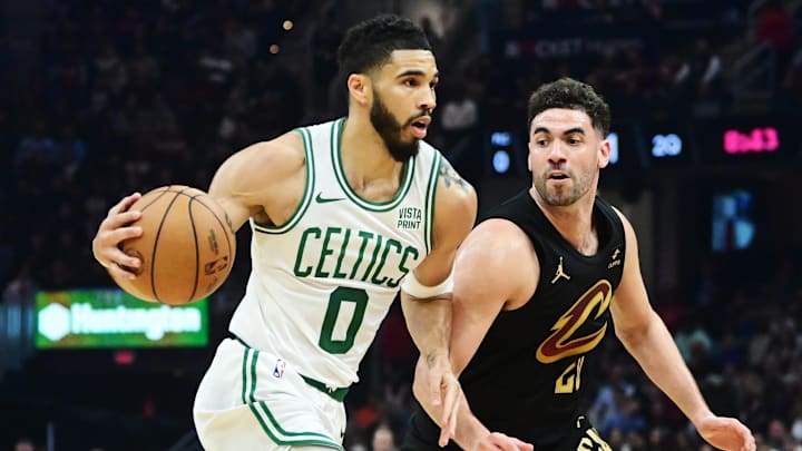 Mar 5, 2024; Cleveland, Ohio, USA;  Boston Celtics forward Jayson Tatum (0) drives to the basket against Cleveland Cavaliers forward Georges Niang (20) during the first half at Rocket Mortgage FieldHouse. Mandatory Credit: Ken Blaze-Imagn Images
