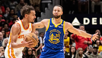 Feb 3, 2024; Atlanta, Georgia, USA; Atlanta Hawks guard Trae Young (11) defends the ball against Golden State Warriors guard Stephen Curry (30) during the fourth quarter at State Farm Arena. Mandatory Credit: Jordan Godfree-Imagn Images