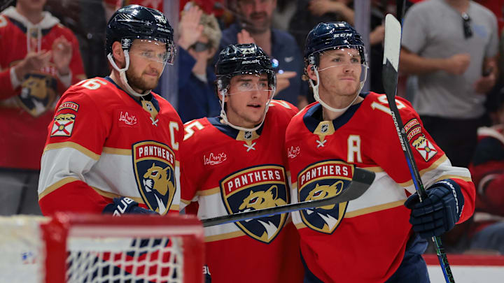 Nov 30, 2024; Sunrise, Florida, USA; Florida Panthers right wing Mackie Samoskevich (center) celebrates with center Aleksander Barkov (left) and left wing Matthew Tkachuk (right) after scoring against the Carolina Hurricanes during the second period at Amerant Bank Arena. Mandatory Credit: Sam Navarro-Imagn Images