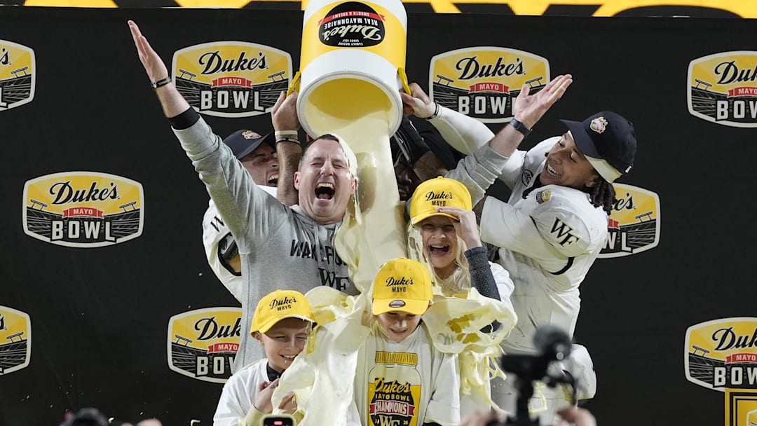 Jan 2, 2026; Charlotte, NC, USA;  Wake Forest Demon Deacons defensive back Nick Andersen (45) and Wake Forest Demon Deacons quarterback Robby Ashford (2) dump mayo on  head coach Jake Dickert and his family receive the traditional mayo dump after Wake Forest Demon Deacons win at Bank of America Stadium. Mandatory Credit: Jim Dedmon-Imagn Images