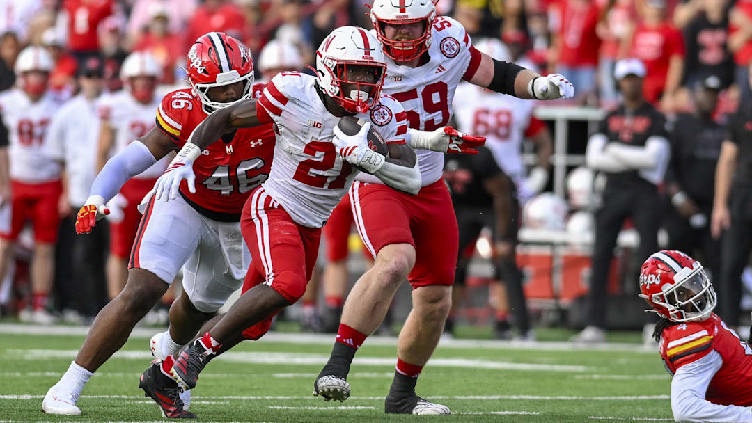 Oct 11, 2025; College Park, Maryland, USA;  Nebraska Cornhuskers running back Emmett Johnson (21) rushes as Maryland Terrapins defensive lineman Dillan Fontus (46) pursues during the first half at SECU Stadium. Mandatory Credit: Tommy Gilligan-Imagn Images