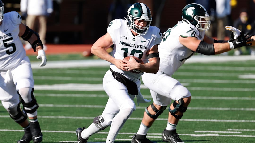Oct 31, 2020; Ann Arbor, Michigan, USA;  Michigan State Spartans quarterback Rocky Lombardi (12) rushes against the Michigan Wolverines at Michigan Stadium. Mandatory Credit: Rick Osentoski-Imagn Images