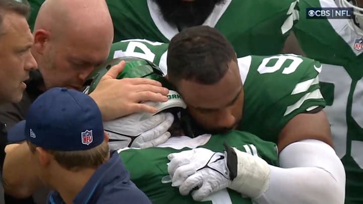 New York Jets defensive tackle Solomon Thomas hugs teammate linebacker Jermaine Johnson as he's carted off the field.